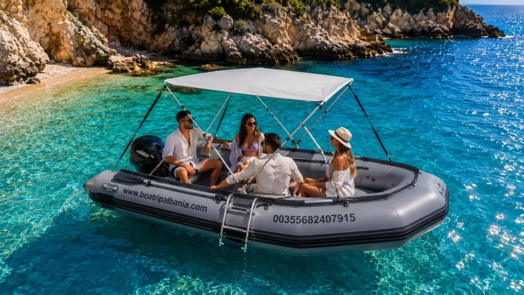 People enjoying a self-drive rental boat in Himare with turquoise sea and rocky coastline.