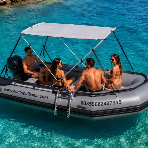 4 person inflatable boat for rent in Himare, Albania, anchored in crystal clear turquoise water.