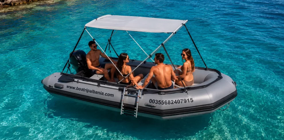 4 person inflatable boat for rent in Himare, Albania, anchored in crystal clear turquoise water.